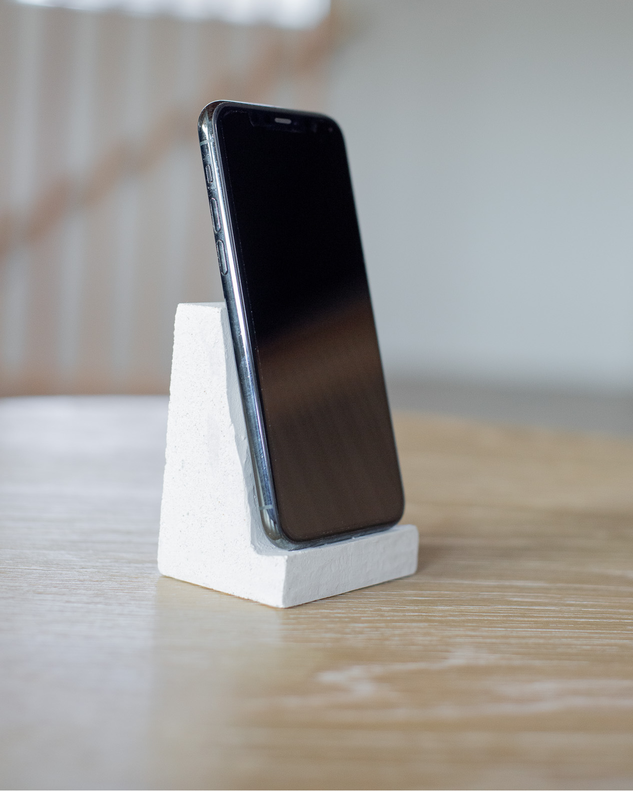 Smartphone on a white stand with a blurred background
