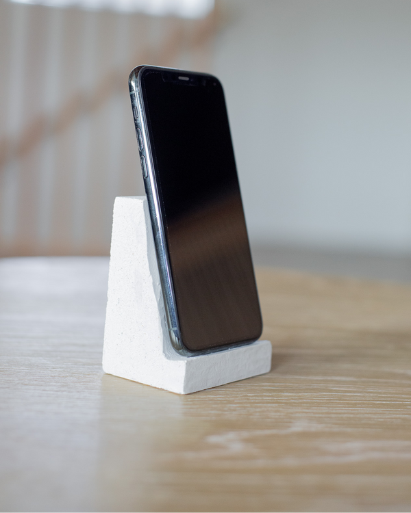 Smartphone on a white stand with a blurred background